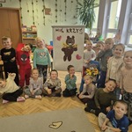 Grupa przedszkolaków obok portretu pluszaka Misia Krzysia