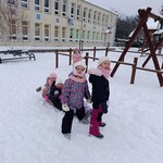 Dzieci z sankami bawiące się na śniegu